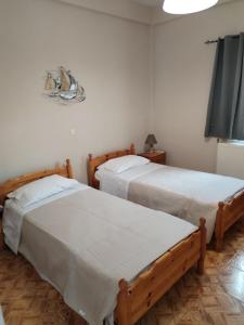 two beds in a room with white walls at Takis House in Gavrio