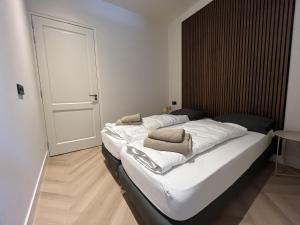 a bedroom with a large bed with white sheets at Appartementen het Centrum in Domburg