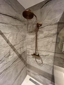 a shower in a bathroom with a stone wall at Appartementen het Centrum in Domburg +40 photos