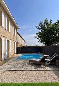 a swimming pool with two lounge chairs next to a building at La Chartreuse du Château La Garde in Martillac +41 photos