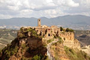 a building on top of a mountain with a tower at La casa sul poggio in Lubriano