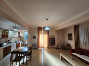 a kitchen and a living room with a table and chairs at Jozi Kaiser Apartment 2 in Durrës