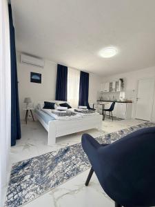 a bedroom with a bed and a chair in it at EFESA Apartments in Visoko