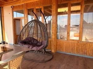 a chair sitting on a table in a room with windows at Ulli Oy Boutique & Terrace in Khiva