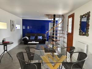 a living room with a glass table and a blue wall at Relais du Chat Prosper in Lescherolles