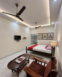 a bedroom with a bed and a couch and a table at Gravity Groups AARA Residency - Near Jipmer in Puducherry Airpoert