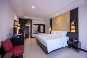 a bedroom with a white bed and a red chair at Horizon Karon Beach Resort & Spa in Karon Beach