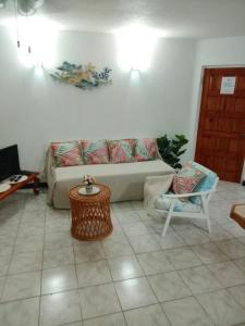 a living room with a couch and a table at Golden Gem Cosy Apartment with pool & garden view in Saint James