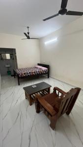 a room with a table and a chair and a bed at Gravity Groups AARA Residency - Near Jipmer in Puducherry Airpoert