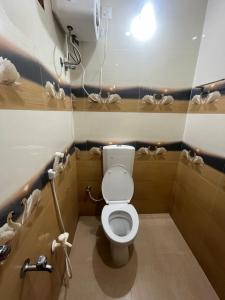 a small bathroom with a toilet and a phone at Gravity Groups AARA Residency - Near Jipmer in Puducherry Airpoert +14 photos