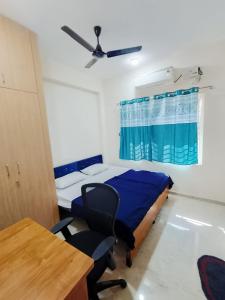 a bedroom with a bed and a chair and a table at RV Comforts in Siruvāchchūr