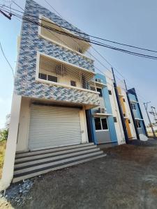 a blue house with a door and a garage at RV Comforts in Siruvāchchūr
