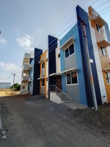 a row of colorful buildings in a parking lot at RV Comforts in Siruvāchchūr