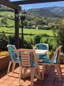 a table and chairs on a patio with a view at Hotel Rural Villa Elena in Panes