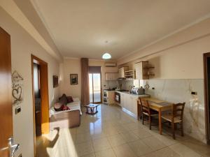 a kitchen and living room with a table and a couch at Jozi Kaiser Apartment 3 in Durrës