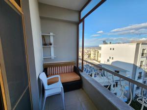 a balcony with a bench and tables and chairs at Jozi Kaiser Apartment 3 in Durrës