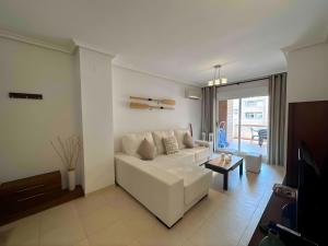 a living room with a white couch and a table at Magic World Vistamar lll in El Borseral