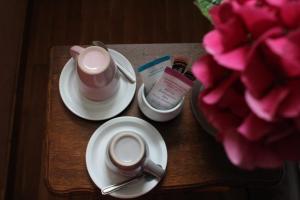 a table with a cup of coffee and a flower at La Table de Gabin in Saint-Léonard