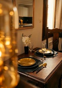 a wooden table with two plates and glasses on it at Appartement Ubac - Chic & Douillet in Saint-Gaudens