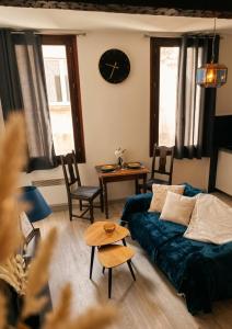 a living room with a bed and a clock on the wall at Appartement Ubac - Chic & Douillet in Saint-Gaudens