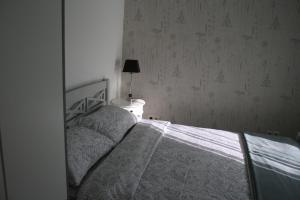 a bedroom with a bed and a lamp on a table at Berzlejas 3 in Upesgrīva