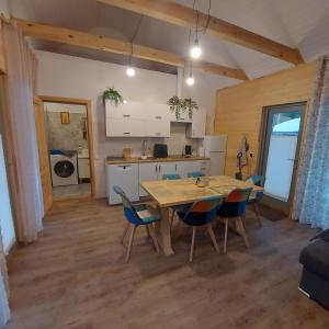 a kitchen and dining room with a table and chairs at Berzlejas 3 in Upesgrīva