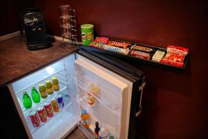 an open refrigerator with food and drinks in it at Suite Phoenix - Maison Cosy avec Terrasse & Cinéma Privé in Angoulême