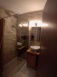 a bathroom with a sink and a glass shower at Le Bredele in Riquewihr