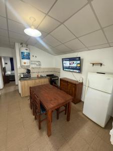 a kitchen with a wooden table and a refrigerator at Potrero Village Suites Refugios Serranos in Potrero de Garay