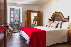 a bedroom with a large bed with a red blanket at Bnbook Ca Du Val in Falmenta