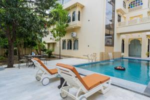 a villa with a swimming pool and two lounge chairs at Virasat-1969 in Udaipur