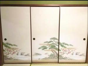 a cabinet with a chinese painting on it at RYU in Hatsukaichi