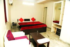 a bedroom with a bed and two chairs and a table at Hotel Royal Maithan International in Garphalbāri