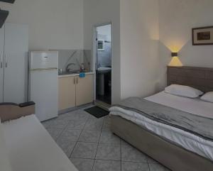 a small bedroom with a bed and a kitchen at Lea home in Vlorë