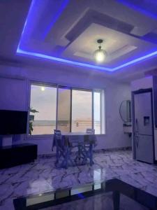 a living room with a table and a view of the ocean at Romantique place in Mahdia