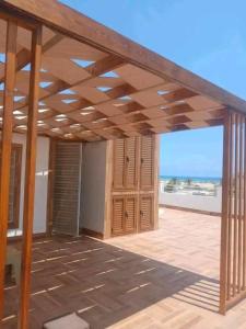 a wooden pergola on a patio with a view of the ocean at Romantique place in Mahdia