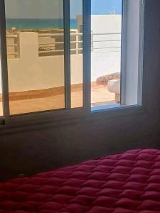 a room with a window with a view of the ocean at Romantique place in Mahdia