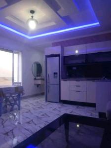a room with a kitchen with a refrigerator and a table at Romantique place in Mahdia