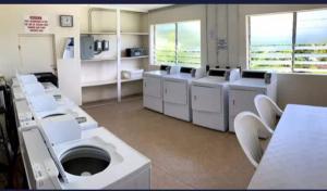a bathroom with a bunch of toilets and sinks at Golden Gem Cosy Apartment with pool & garden view in Saint James