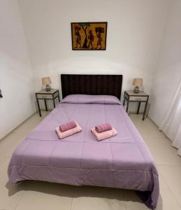 a bedroom with a purple bed with two pink pillows at Casa Bucalo 2, Taormina in Taormina
