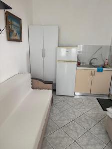 a kitchen with a white refrigerator and a white couch at Lea home in Vlorë