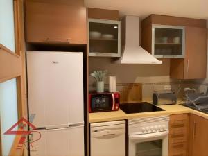 a kitchen with a white refrigerator and a microwave at Magic World Vistamar lll in El Borseral