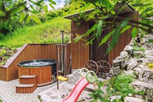 a garden with a hot tub and a red slide at Chata Dolinka in Liptovské Revúce +47 photos