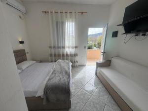 a bedroom with a bed and a window and a couch at Lea home in Vlorë