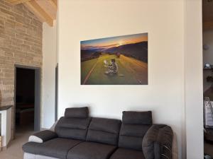 a living room with a couch and a painting on the wall at Maison chez Louis in Asuel