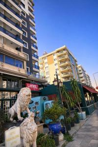 a couple of statues of tigers in front of buildings at Lion Park Suites & Residence Hotel in Aydın