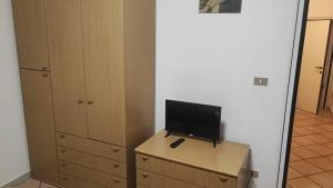 a room with a desk with a television on a dresser at Bed & Breakfast Porta Santi in Cesena