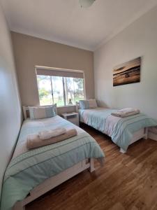 a bedroom with two beds and a window at Abbivale Farm Cottage in Harewood