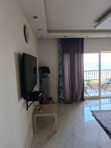 a living room with a flat screen tv on a wall at بورتو السخنه الاهرامات in Banī Ghālib