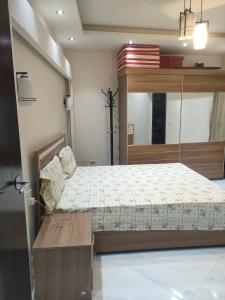 a bedroom with a large bed and a table at بورتو السخنه الاهرامات in Banī Ghālib